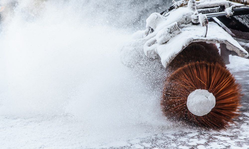 Snow plow does removal after blizzard in winter. Snow blower in motorway. Winter service on road